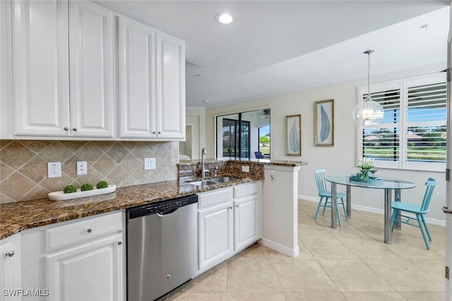 3159 Serena Ln Unit 102, Naples, FL 34114 - kitchen with stainless steel dishwasher, a sink, white cabinets, baseboards, and decorative backsplash