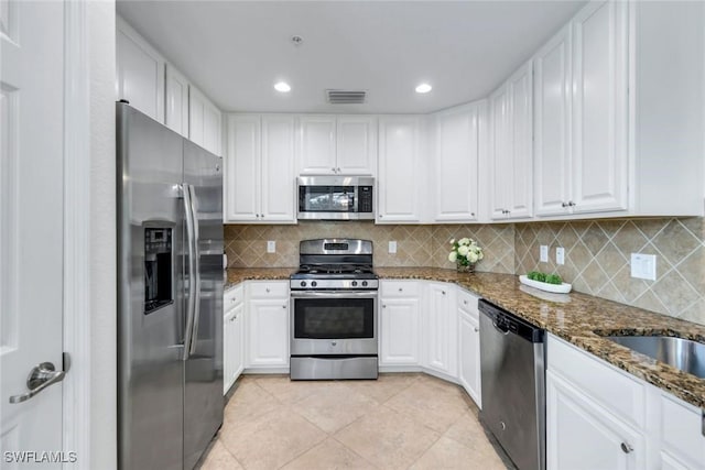 3159 Serena Ln Unit 102, Naples, FL 34114 - kitchen featuring appliances with stainless steel finishes, white cabinetry, dark stone counters, light tile patterned flooring, and recessed lighting