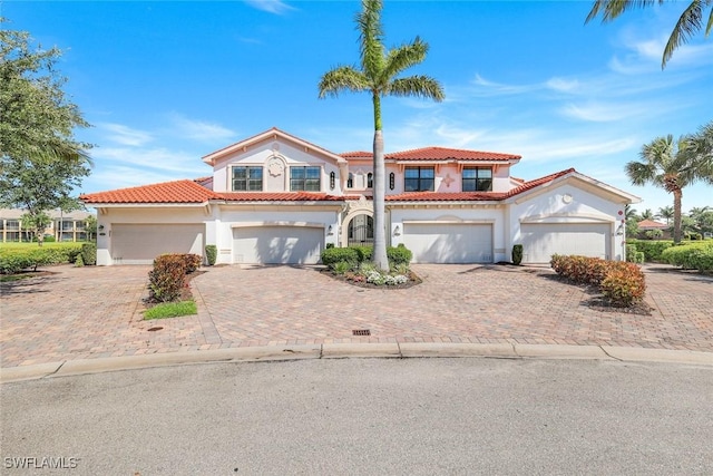 3159 Serena Ln Unit 102, Naples, FL 34114 - mediterranean / spanish house with stucco siding, decorative driveway, a tile roof, and a garage