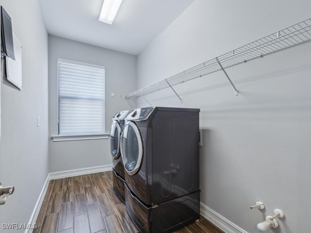 clothes washing area featuring independent washer and dryer, baseboards, and dark wood-style flooring