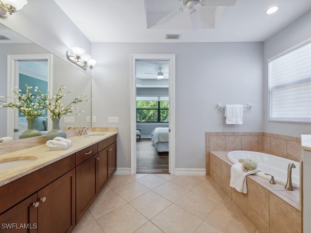 ensuite bathroom featuring ceiling fan, a garden tub, tile patterned floors, double vanity, and recessed lighting