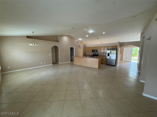 3206 35th St W, Lehigh Acres, FL 33971 - kitchen featuring stainless steel appliances, open floor plan, arched walkways, vaulted ceiling, and baseboards