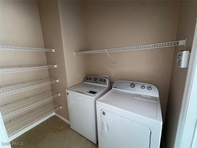 3206 35th St W, Lehigh Acres, FL 33971 - washroom with separate washer and dryer, light tile patterned floors, and baseboards