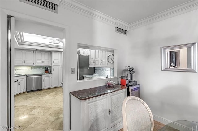 174 S Collier Blvd Unit 304, Marco Island, FL 34145 - kitchen with appliances with stainless steel finishes, ornamental molding, tasteful backsplash, and white cabinets