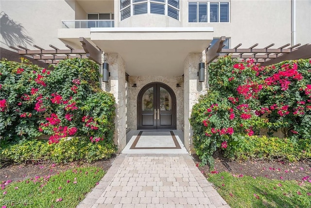 2630 Grey Oaks Dr N Unit B18, Naples, FL 34105 - doorway to property featuring stucco siding, a pergola, french doors, and stone siding