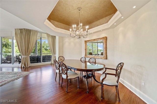 2630 Grey Oaks Dr N Unit B18, Naples, FL 34105 - dining room featuring a tray ceiling, baseboards, a chandelier, wood finished floors, and healthy amount of natural light