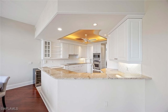 2630 Grey Oaks Dr N Unit B18, Naples, FL 34105 - kitchen featuring a raised ceiling, stainless steel appliances, wine cooler, recessed lighting, and backsplash