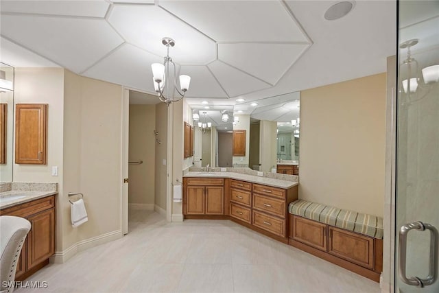 2630 Grey Oaks Dr N Unit B18, Naples, FL 34105 - bathroom with baseboards, a chandelier, two vanities, and a shower with shower door