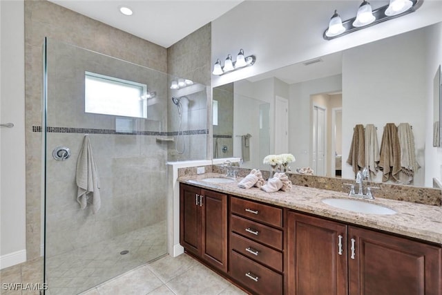 full bathroom featuring a walk in shower, double vanity, and tile patterned flooring