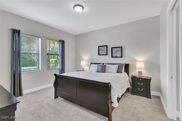 bedroom featuring light carpet and baseboards