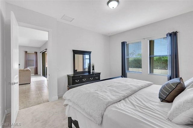bedroom with baseboards, light colored carpet, and light tile patterned flooring