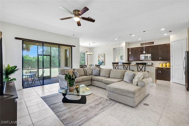 living room with a ceiling fan, light tile patterned flooring, recessed lighting, and a chandelier
