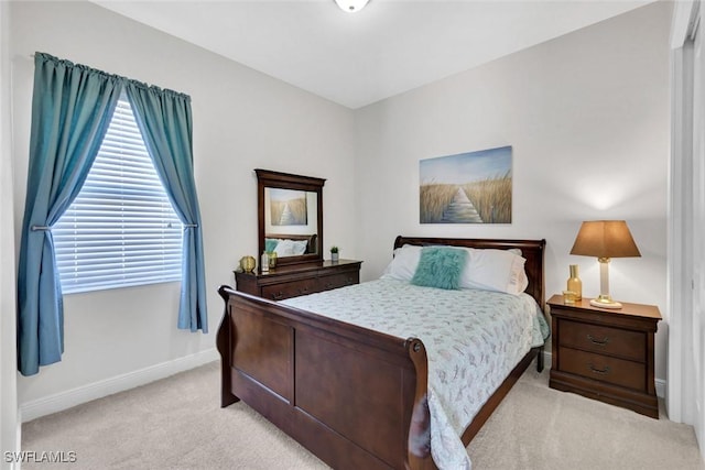 bedroom featuring light carpet and baseboards