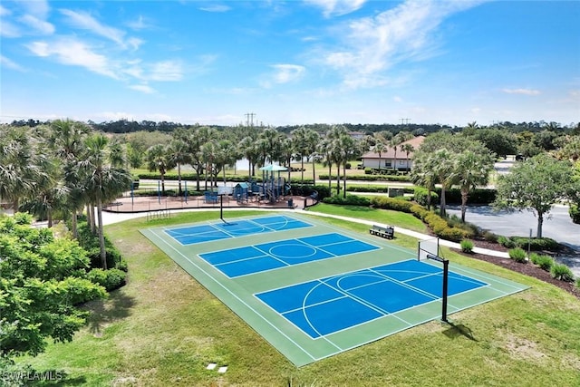 view of sport court featuring community basketball court, a lawn, and view of scattered trees