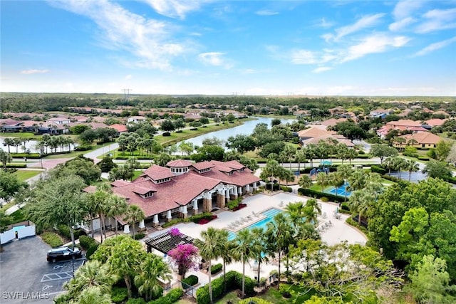 aerial perspective of suburban area featuring a large body of water and a pool area