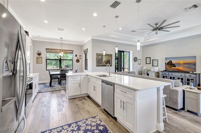 7824 7th Ter, Labelle, FL 33935 - kitchen with stainless steel appliances, open floor plan, a sink, light wood-style floors, and crown molding