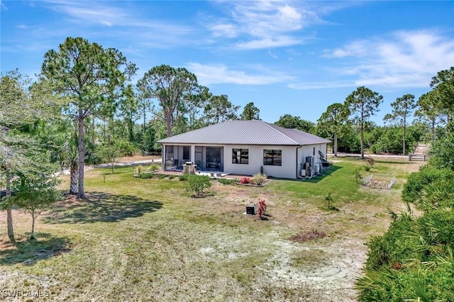 7824 7th Ter, Labelle, FL 33935 - back of house featuring a sunroom, metal roof, a lawn, and view of wooded area