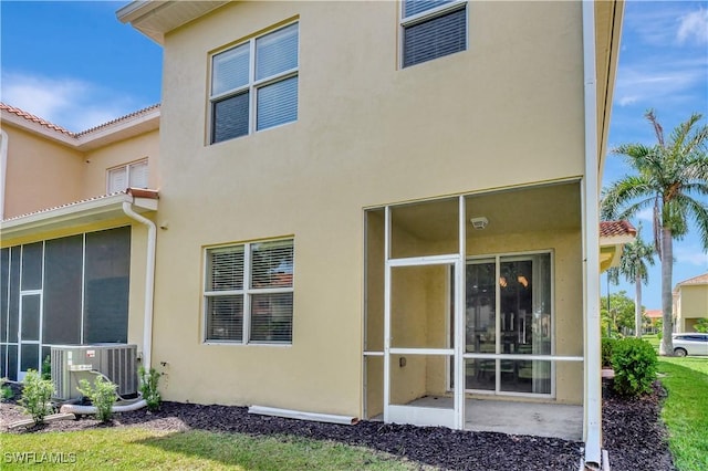 9820 Healthpark Cir Unit 101, Fort Myers, FL 33908 - rear view of house with stucco siding, central AC, and a sunroom