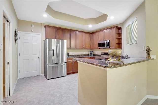 9820 Healthpark Cir Unit 101, Fort Myers, FL 33908 - kitchen featuring appliances with stainless steel finishes, open shelves, dark stone countertops, a peninsula, and baseboards