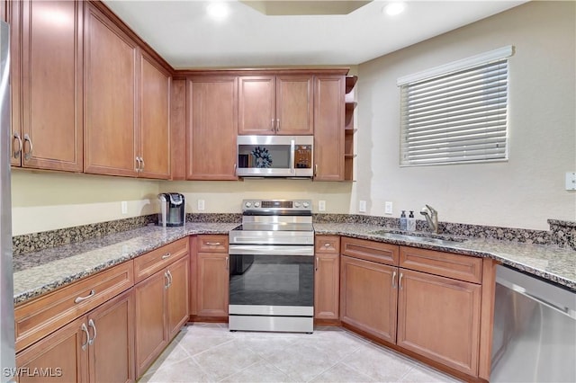 9820 Healthpark Cir Unit 101, Fort Myers, FL 33908 - kitchen featuring stainless steel appliances, a sink, recessed lighting, stone counters, and brown cabinets