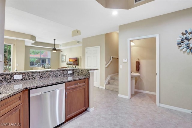 9820 Healthpark Cir Unit 101, Fort Myers, FL 33908 - kitchen featuring dishwasher, brown cabinetry, a ceiling fan, stone countertops, and baseboards