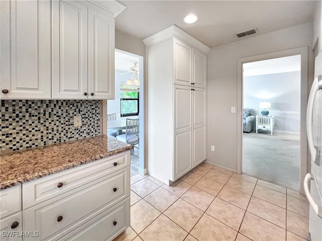 13264 White Marsh Ln Unit 3318, Fort Myers, FL 33912 - kitchen with white cabinets, tasteful backsplash, light stone counters, light tile patterned floors, and recessed lighting