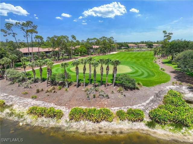 view of community with view of golf course, a water view, and view of scattered trees