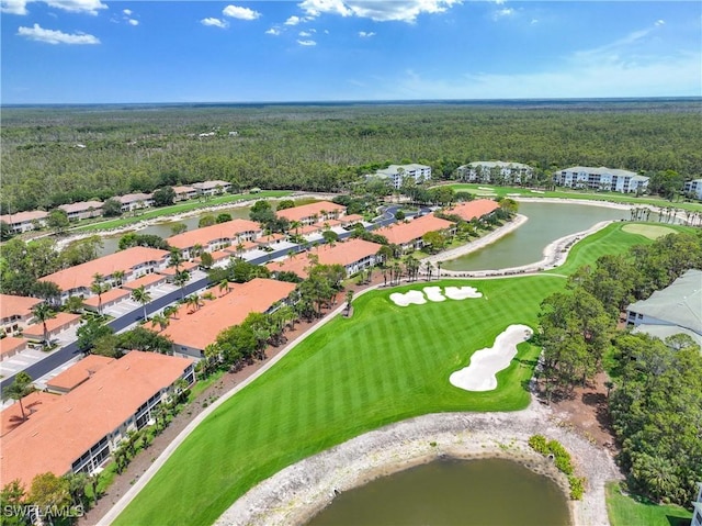 drone / aerial view of a forest, a nearby body of water, and a golf club