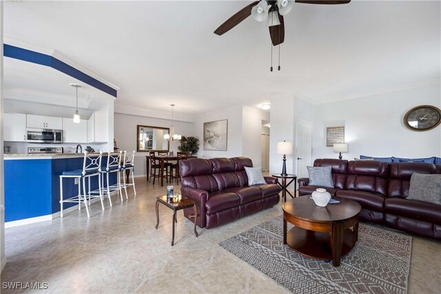 living room with ornamental molding, ceiling fan, and a chandelier