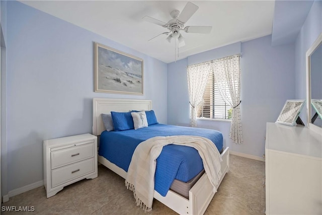 bedroom featuring baseboards, ceiling fan, and light tile patterned floors