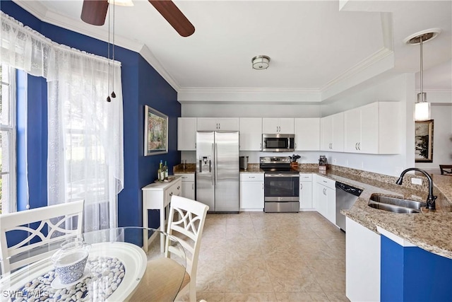kitchen with appliances with stainless steel finishes, a sink, ceiling fan, white cabinets, and pendant lighting