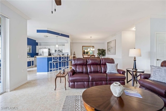 living room featuring ornamental molding, a chandelier, ceiling fan, and baseboards