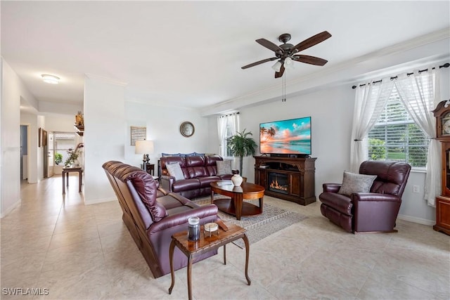 living room with a warm lit fireplace, ceiling fan, light tile patterned floors, crown molding, and baseboards