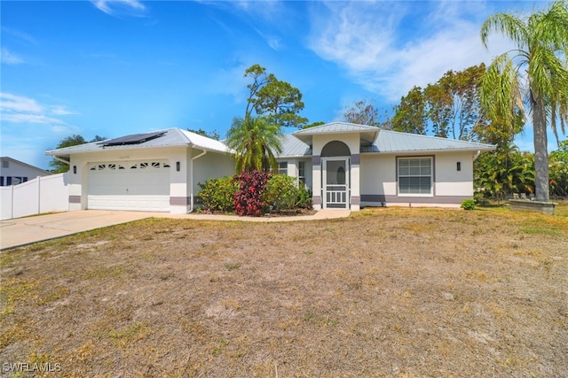 18298 Hepatica Rd, Fort Myers, FL 33967 - ranch-style house featuring stucco siding, solar panels, a garage, concrete driveway, and metal roof