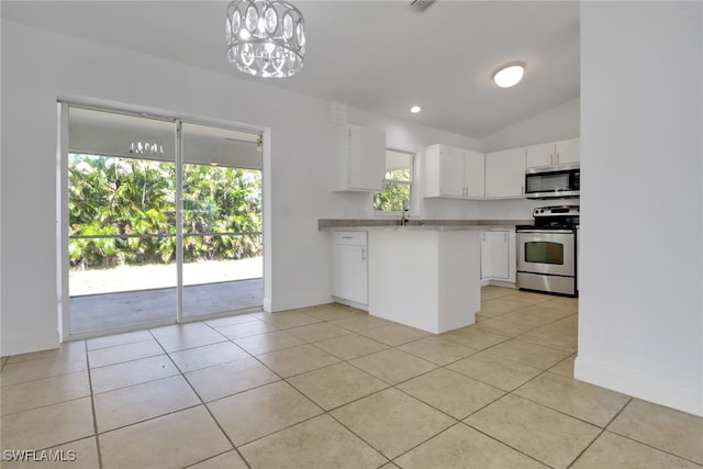 18298 Hepatica Rd, Fort Myers, FL 33967 - kitchen with appliances with stainless steel finishes, white cabinetry, light countertops, light tile patterned floors, and vaulted ceiling