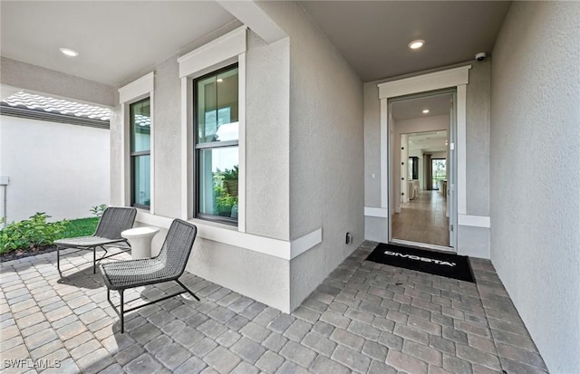 12429 Basalt Ln, Alva, FL 33982 - doorway to property featuring stucco siding and a security system