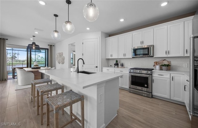 12429 Basalt Ln, Alva, FL 33982 - kitchen with stainless steel appliances, a sink, decorative backsplash, an island with sink, and recessed lighting