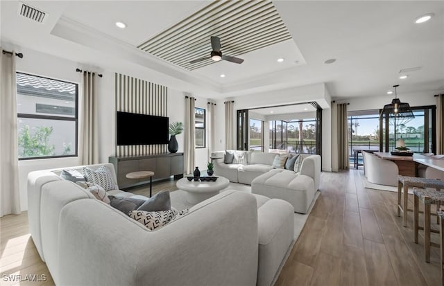 12429 Basalt Ln, Alva, FL 33982 - living room with a tray ceiling, hardwood / wood-style flooring, ceiling fan, and recessed lighting