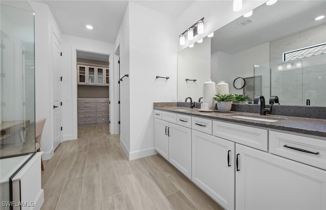 12429 Basalt Ln, Alva, FL 33982 - full bathroom featuring a stall shower, double vanity, baseboards, wood finished floors, and recessed lighting