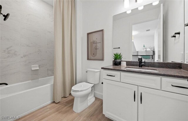 12429 Basalt Ln, Alva, FL 33982 - bathroom with wood finished floors, toilet, vanity, shower / bath combination with curtain, and baseboards