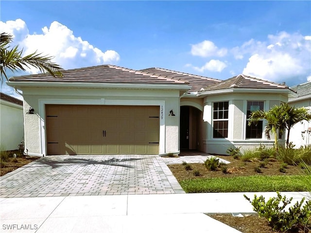 12429 Basalt Ln, Alva, FL 33982 - ranch-style home featuring decorative driveway, a garage, a tiled roof, and stucco siding