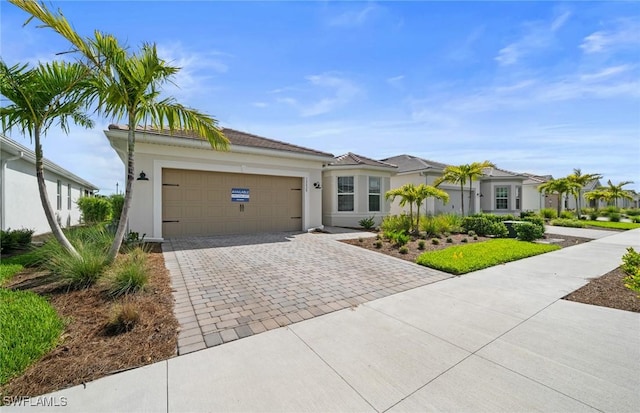 12429 Basalt Ln, Alva, FL 33982 - view of front of home featuring decorative driveway, an attached garage, and stucco siding