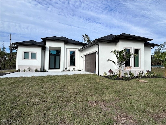prairie-style house with stucco siding, a garage, and a front lawn
