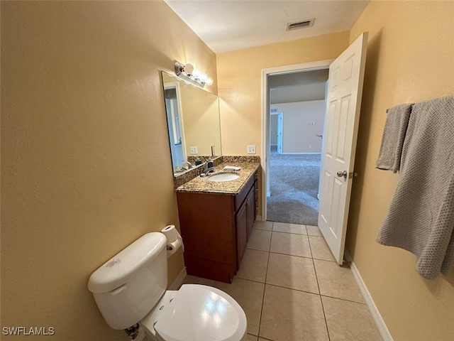 half bath featuring vanity, tile patterned flooring, toilet, and baseboards