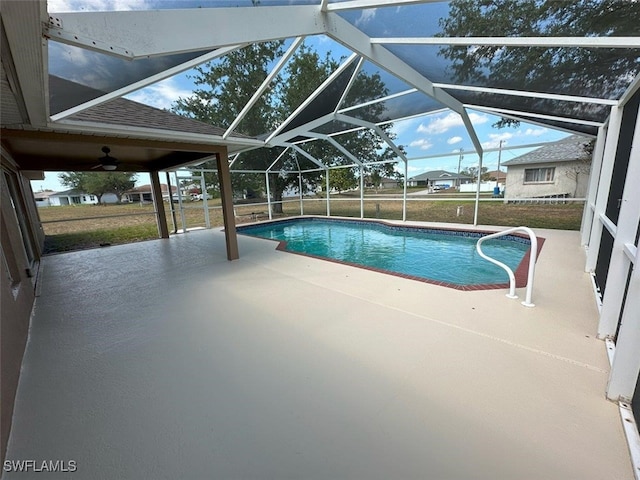 swimming pool with a patio area and glass enclosure