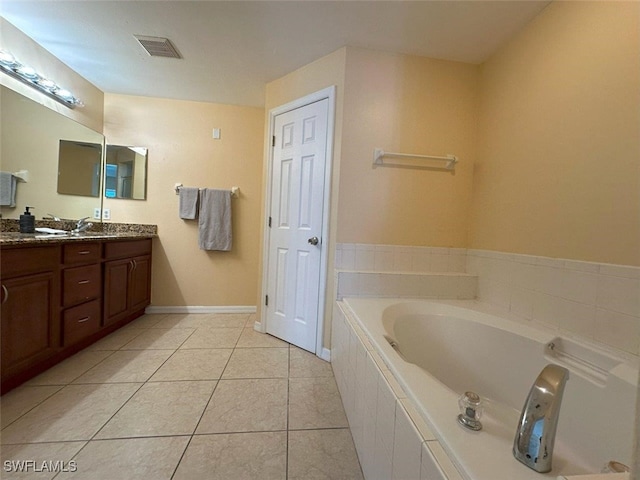 bathroom featuring a bath, tile patterned flooring, vanity, and baseboards