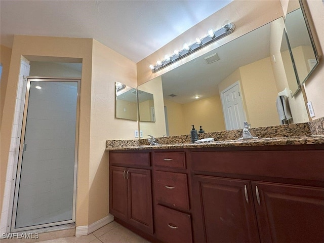 full bathroom with a shower stall, tile patterned floors, baseboards, and double vanity