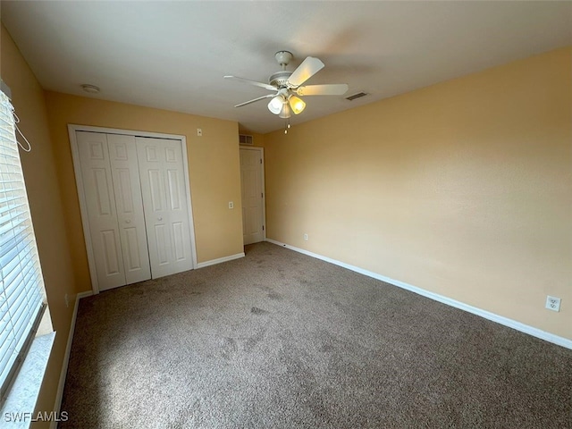 unfurnished bedroom featuring carpet, a closet, baseboards, and a ceiling fan