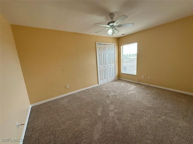 unfurnished bedroom with carpet, baseboards, a closet, and ceiling fan
