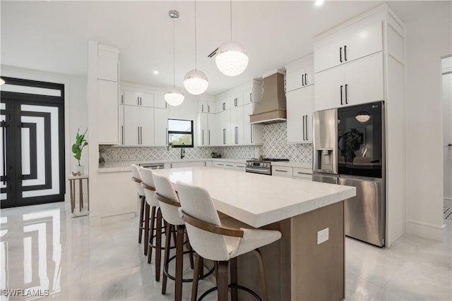 24131 Cock Robin Ln, Bonita Springs, FL 34135 - kitchen featuring custom exhaust hood, stainless steel appliances, a breakfast bar area, a kitchen island, and backsplash